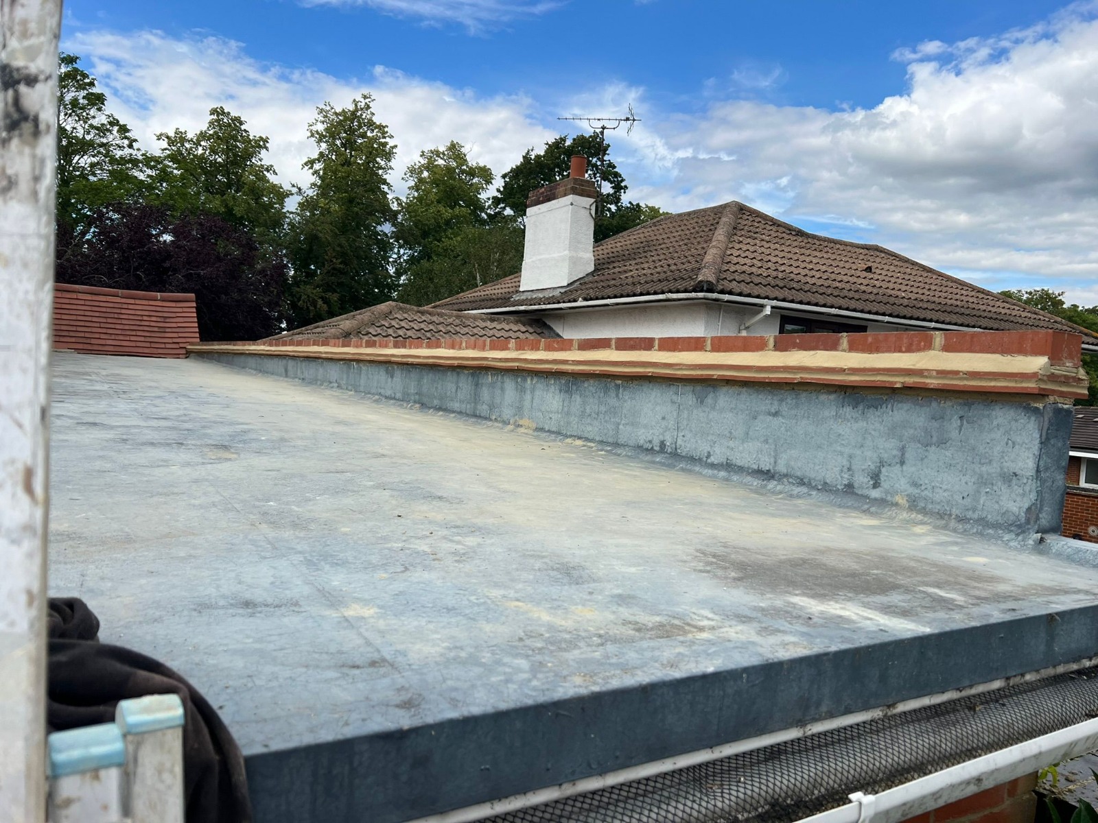 Flat roof finished with a brick parapet and coping